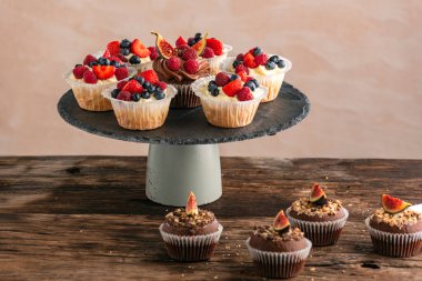 Çikolatalı ve vanilyalı kekler. Masanın üzerinde böğürtlen karışımı. Meyveli kek.