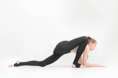 Genç ince jimnastikçi kız beyaz arka planda esneklik geliştirmek için egzersiz yapıyor. Yogada Asanas