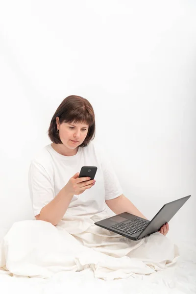 Mujer Negocios Con Portátil Teléfono Cama Contra Una Pared Blanca — Foto de Stock