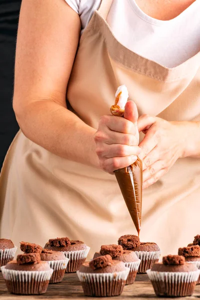Kobieta Ozdabia Babeczki Kremem Kakaowym Kuchni Ręka Cukiernika Przygotowuje Czekoladowe — Zdjęcie stockowe