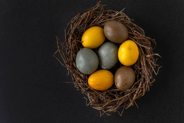 Ptasie Gniazdo Kolorowymi Żółtymi Brązowymi Jajkami Wielkanocnymi Czarnym Stole Odbiór — Zdjęcie stockowe