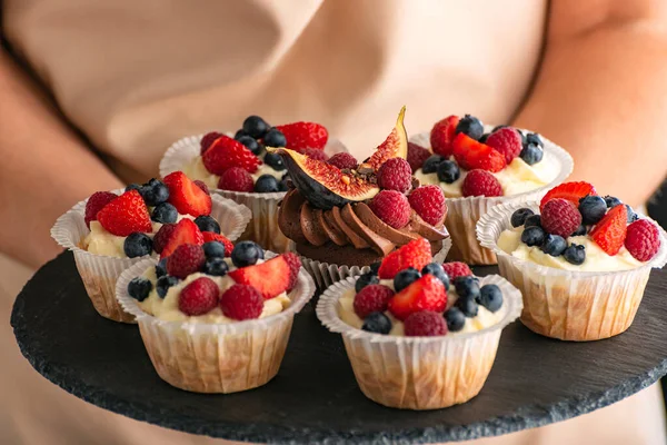 Böğürtlen karışımıyla süslenmiş taze ağız. Tabakta ev yapımı vanilyalı kek. Kapat.