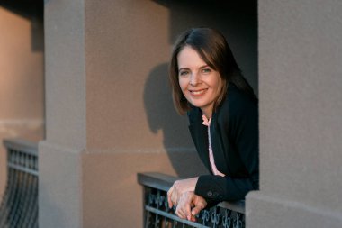 Siyah takım elbiseli mutlu bir iş kadını. Molada gülümseyen kadın patron. İş kaçamağı. Kameraya bakan bir model..