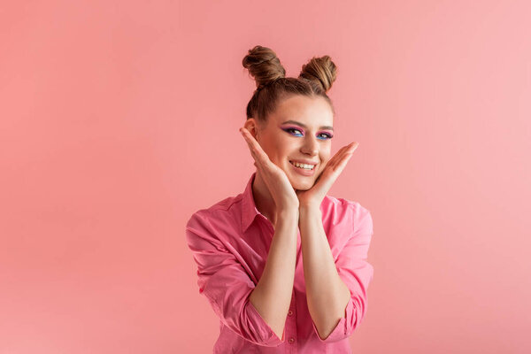 Funny girls with pigtails in pink shirt on pink background. Two bun hairstyle. Concept of naivety