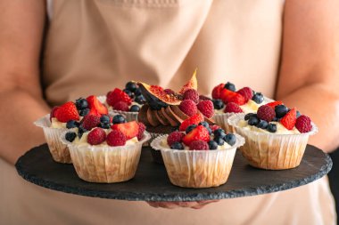 Tabakta ev yapımı vanilyalı kek. Kapatın. Böğürtlen karışımıyla süslenmiş taze ağız.