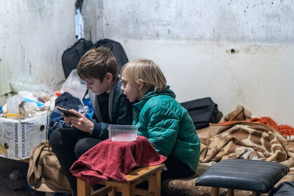 Харьков, Украина - 3 марта 2022 года: Украинские дети сидят в бомбоубежище, в то время как российские войска бомбят жилые районы мирными жителями