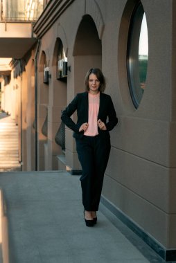 Siyah takım elbise ve topuklu ayakkabı giyen başarılı bir yönetmen. Resmi iş kıyafetleri içinde bir iş kadını. Sokak portresi.