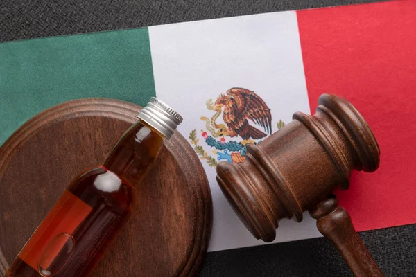 墨西哥国旗背景上的酒瓶和木槌 在墨西哥 酒精的概念与法律冲突 — 图库照片
