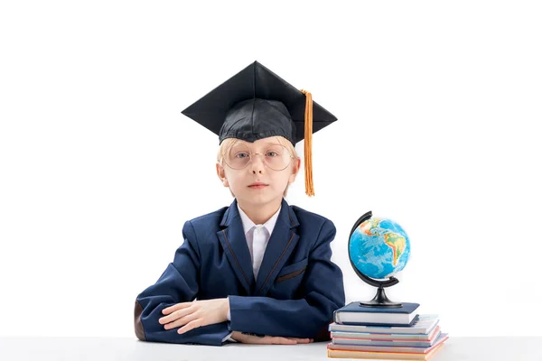 Serious Boy Sitting Desk Next Notebooks Glob Isolated White Background — Stock Photo, Image