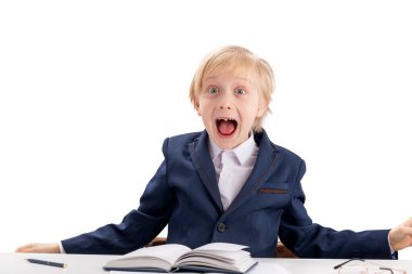 Screaming fidget boy in school uniform. First grader boy fools around while performing lessons. Difficulty concentrating in children