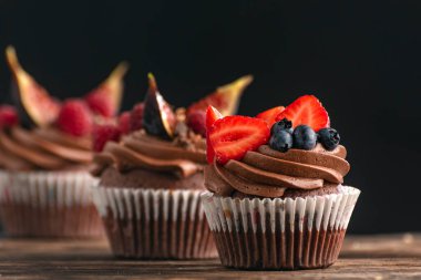 Taze meyve ve böğürtlenlerle süslenmiş çikolatalı kek. Kremalı çikolatalı kek. Kapat.