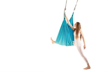 Slim woman engaged in class of aero yoga in hammocks antigravity isolated on white background. Aerial gymnastics