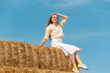 Çiftlikteki samanlıkta güzel bir kadının portresi. Kırsal alanda güneşli bir gün. Hasat. Yaz tatili
