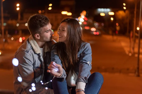 Casal Amantes Estão Sentados Fundo Cidade Noite Com Guirlanda Suas — Fotografia de Stock