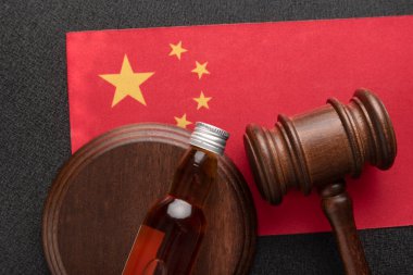 Judges Gavel and bottle of alcohol on China flag. Alcohol legislation. Law and order concept. Alcohol problems in China