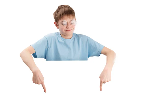 可笑的学童戴着大眼镜 手指指向空荡荡的地方 白色的背景与世隔绝 男孩把他的手指朝下 — 图库照片