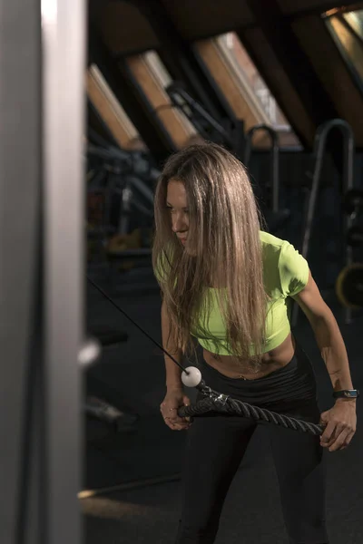 스포츠 레깅스 트레인을 체육관에 있습니다 소녀는 시뮬레이터로 운동을 모습을 보여준다 — 스톡 사진