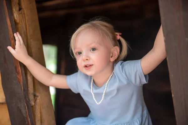Portrait Little Blonde Girl Blue Dress Beads Her Neck Child — стоковое фото