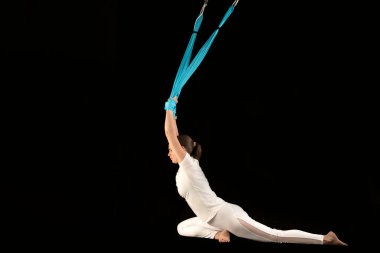 Mavi hamakta havadan uçuş yoga egzersizleri. Arkayı geriyorum. Aero anti yerçekimi yogası. Hava jimnastiği