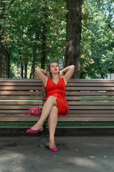Kırmızı Elbiseli Kırmızı Rujlu Çekici Genç Bir Kadın Parkta Bir — Stok fotoğraf