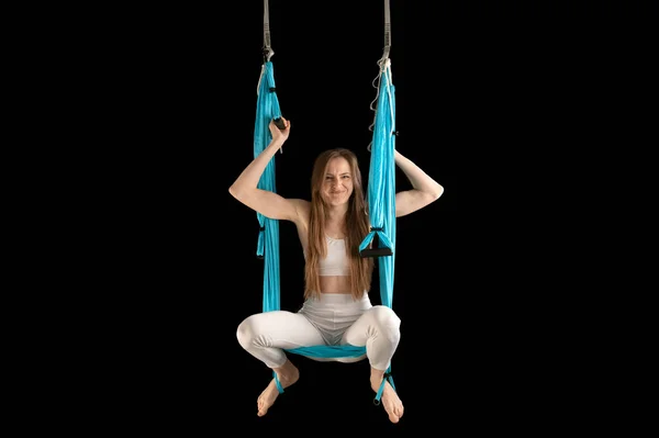 Girl try to practice with sports hammock. Exercise aerial gymnastics. Anti-gravity yoga