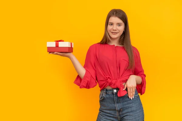 Lächelndes Junges Mädchen Hält Geschenkkarton Der Hand Auf Leuchtend Gelbem — Stockfoto