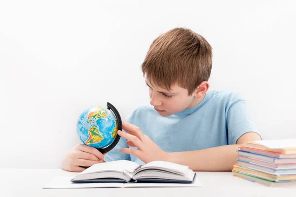 Seriöser Schuljunge Mit Globus Und Buch Schreibtisch Auf Weißem Hintergrund — Stockfoto