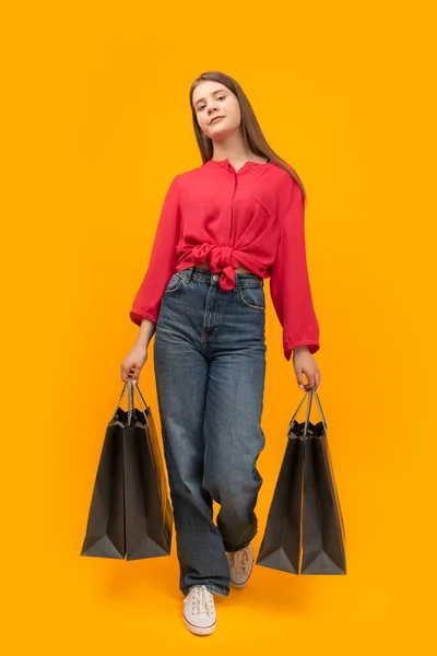Stylish Young Girl Holds Several Paper Bags Shopping Yellow Background — ストック写真