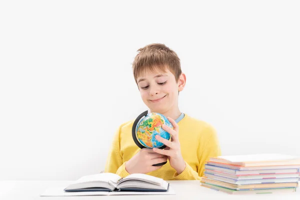 Smiling Schoolboy Sits Table Carefully Studies Globe Boy Yellow Jumper — Stockfoto
