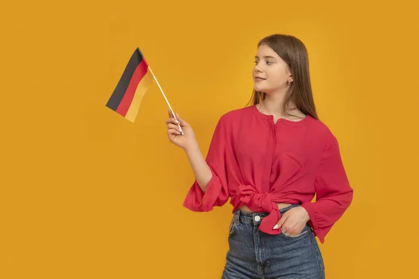 Молода Дівчина Тримає Прапор Німеччини Помаранчевому Тлі Школа Німеччини Вивчи — стокове фото
