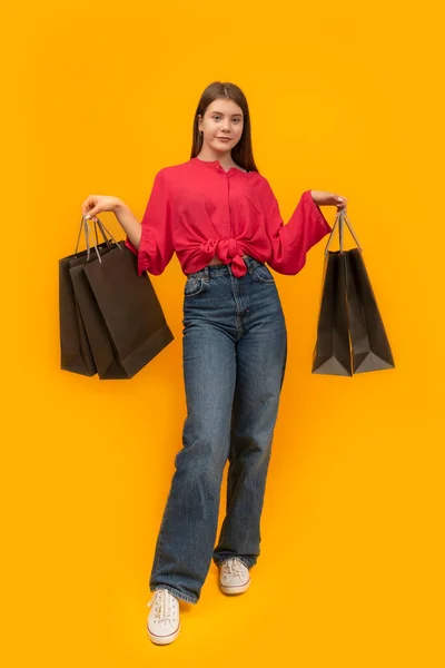 Attractive Young Girl Paper Bags Her Hands Bright Yellow Background — Zdjęcie stockowe