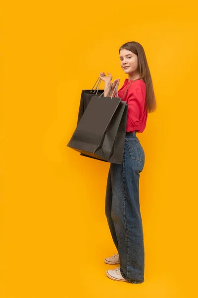 Beautiful Young Girl Holds Black Paper Bags Shopping Yellow Background — ストック写真
