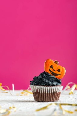 Pembe arka planda zencefilli kurabiye kabaklarıyla süslenmiş komik kek. Bayramlık Cadılar Bayramı keki.