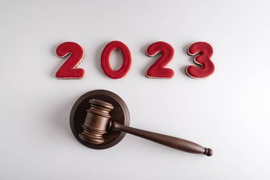 Kırmızı harfli 2023 ve beyaz arka planda hakimler tokmak ya da çekiç. Yeni yılda mahkeme..