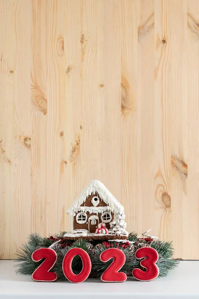 ジンジャーブレッドハウスと碑文2023 メリークリスマス背景 コピースペース 縦の枠 背景に軽い木の壁 — ストック写真