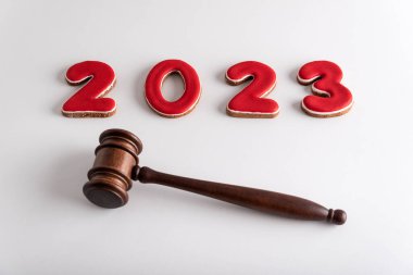 Kırmızı harfli 2023 ve beyaz arka planda hakimler tokmak ya da çekiç. Yeni yılda mahkeme..
