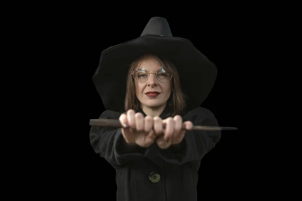 魔女の服の肖像画の魅力的な女の子 眼鏡をかけ 黒の帽子と黒の背景に孤立したコートを身に着けている女性 — ストック写真