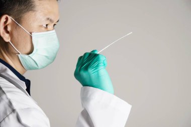 Asyalı doktor hızlı antijen testi hazırlıyor. Covid - 19 otomatik repid test seti.