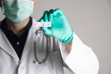 Doktor hızlı antijen testi gösteriyor. Covid - 19 otomatik repid test seti.
