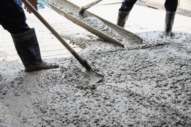 İnşaat alanında yer betonu döken işçiler.