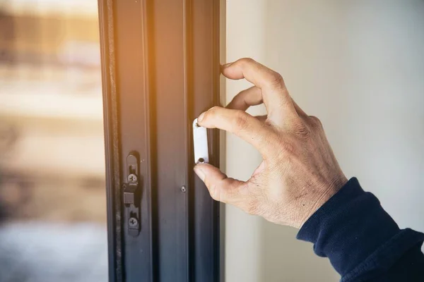 Man doing aluminum frame with glasses and wire screen door and window installation work in construction site