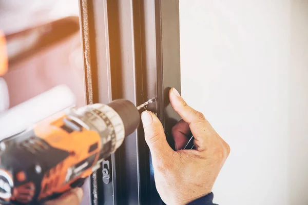 Man doing aluminum frame with glasses and wire screen door and window installation work in construction site