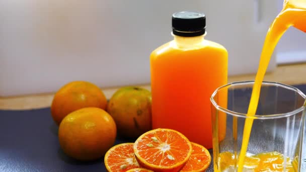 Giet Sinaasappelsap Een Glas Met Oranje Fles Voorbereiding Keuken Achtergrond — Stockvideo