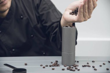 Asyalı barista el kahvesi öğütücüsü kullanıyor. Sıcak kahve yapmak için hazırlayın.