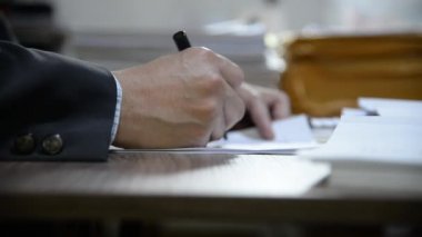 Öğretmen sınıf öğrencilerinin sınav kağıtlarını kontrol ediyor.