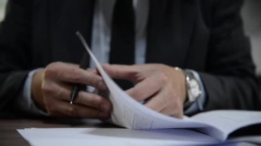 Öğretmen sınıf öğrencilerinin sınav kağıtlarını kontrol ediyor.