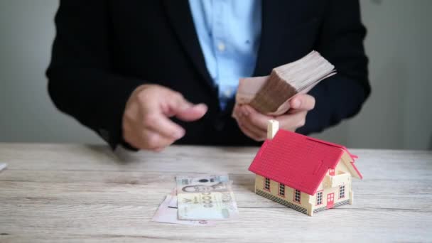 ビジネスマンは住宅ローンの支払いのために現金のお金を計算している — ストック動画