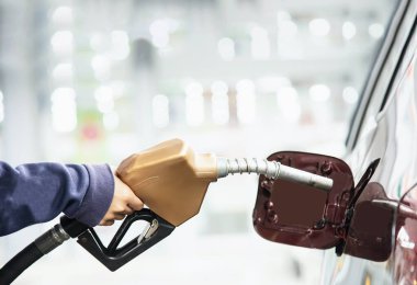 Adam arabasını bir pompa gaz istasyonunda benzin yakıt koyarak