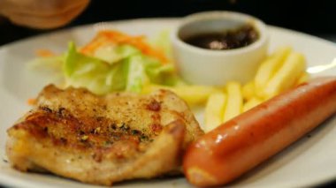 Sosis kızarmış patates ve salata yemek tavuk biftek sosu bırakarak insanlar closeup