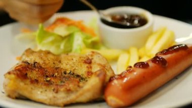 Sosis kızarmış patates ve salata yemek tavuk biftek sosu bırakarak insanlar closeup